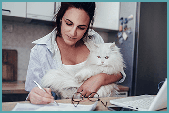 woman holding cat and filling out forms